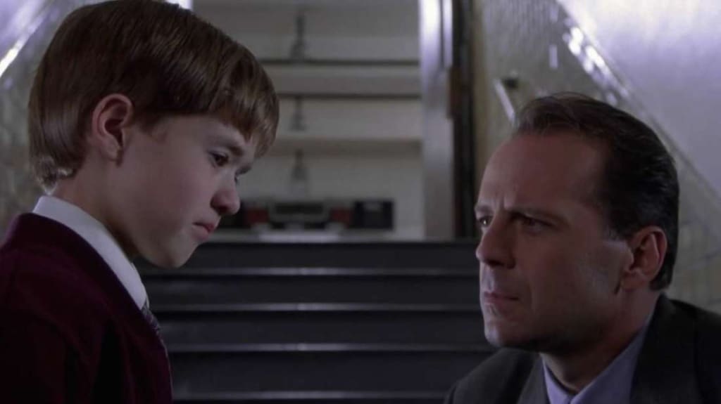 Cole (Haley Joel Osment) y el Doctor Malcom (Bruce Willis) en The Sixth Sense (1995).