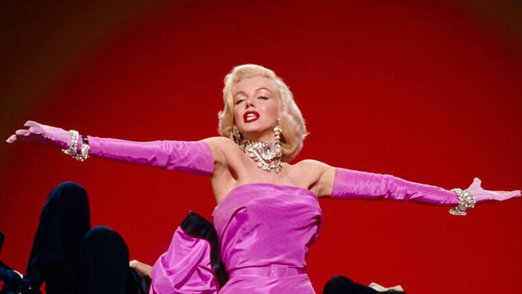 Marilyn Monroe con los brazos abierto y un vestio rosado