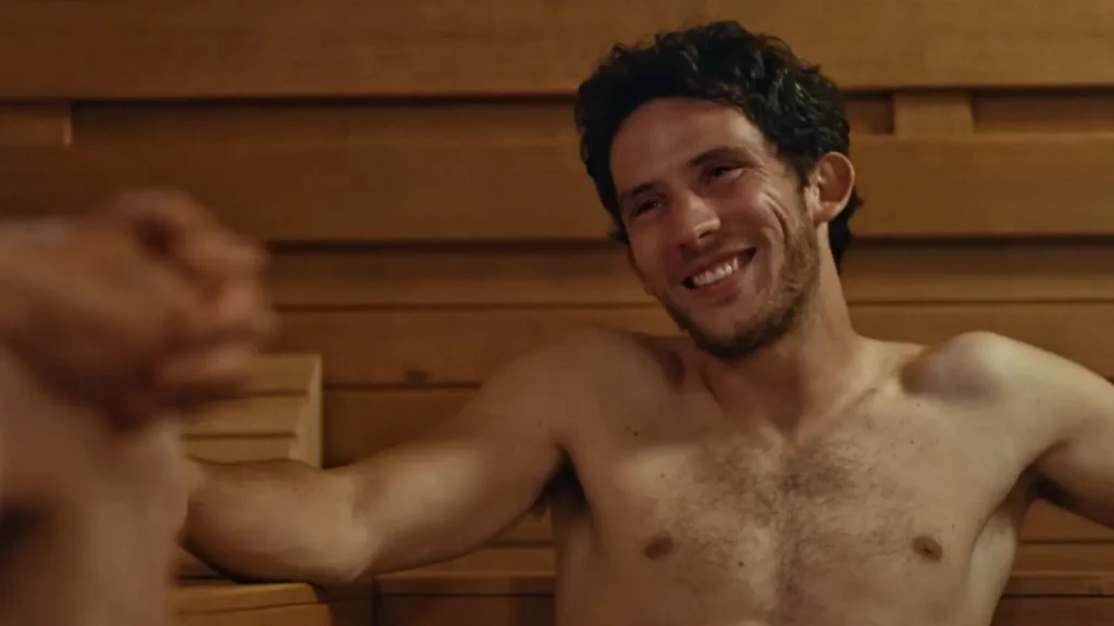 Josh O’Connor en un baño riendose