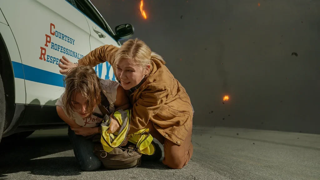 Kristen Dunst protegiendose de una explosión en Civil War la película de Alex Garland
