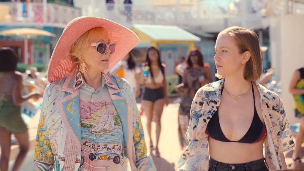 Jean Smart y Hannah Einbinder caminando junto a una piscina en una escena de la serie Hacks