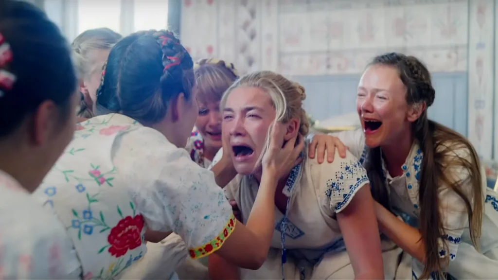 Florence Pugh grita rodeada de mujeres en una escena intensa de Midsommar (2019), la película de terror psicológico dirigida por Ari Aster.