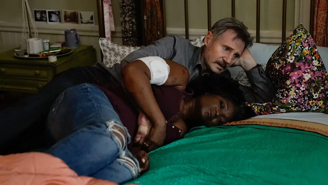 Liam Neeson y Yolonda Ross en una escena íntima de la película Absolution (Implacable), acostados en una cama tras un momento de tensión.