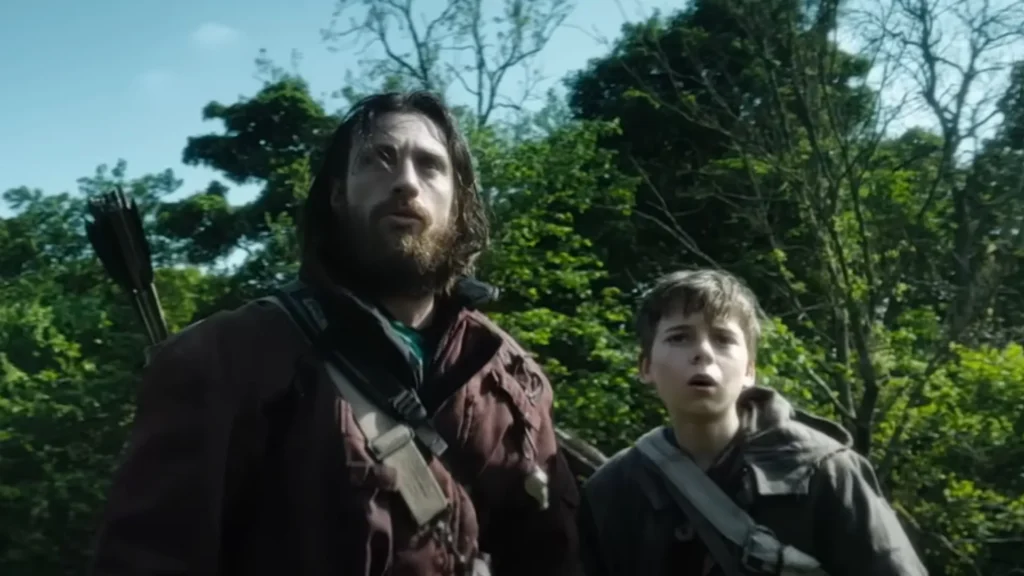Escena de 28 Años Después con Aaron Taylor-Johnson y su hijo en la historia, ambientada en un entorno postapocalíptico