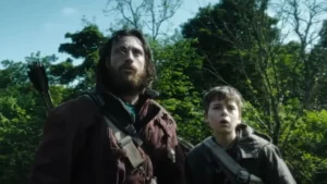 Escena de 28 Años Después con Aaron Taylor-Johnson y su hijo en la historia, ambientada en un entorno postapocalíptico