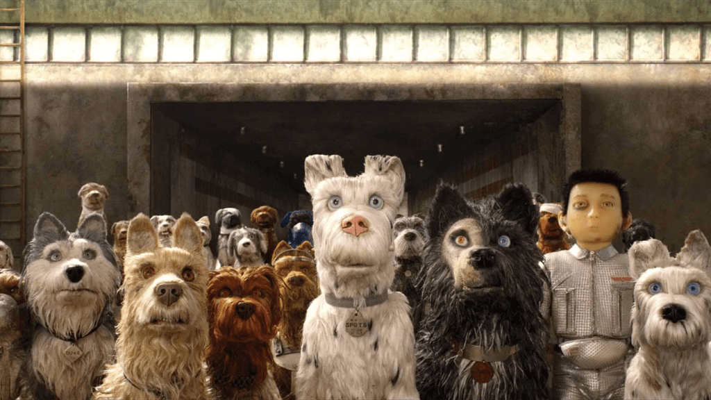 Grupo de perros animados y el joven Atari en una escena de la película "Isle of Dogs" (2018) dirigida por Wes Anderson.