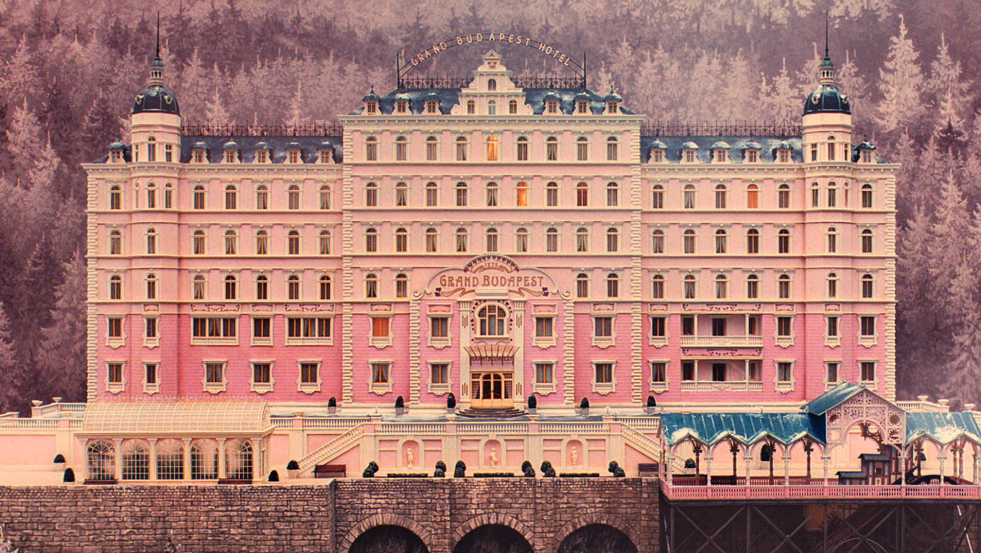 Fachada del icónico Grand Budapest Hotel en la película homónima dirigida por Wes Anderson, con su distintiva arquitectura rosa y estilo visual simétrico.